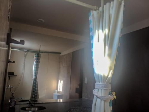 a bathroom with a shower curtain and a sink at La Casita Alquiler Temporario in Merlo