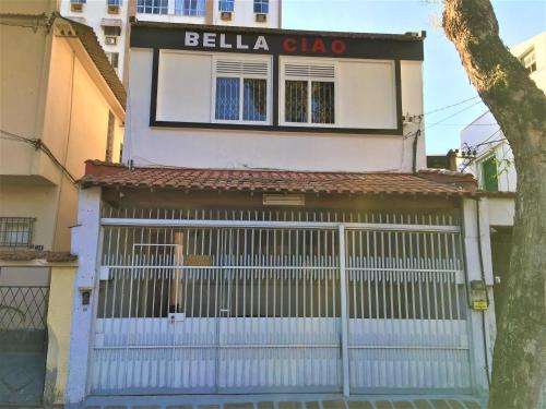 um edifício com um portão branco com um sinal em Bella Ciao Hostel no Rio de Janeiro