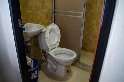 a bathroom with a toilet and a sink at Hotel Central Fusa in Fusagasuga