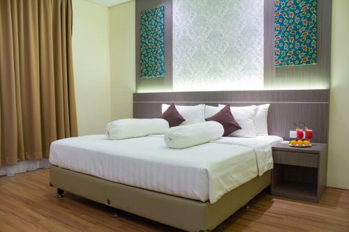 A bed or beds in a room at Nevada Ketapang Hotel