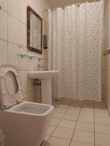 a white bathroom with a toilet and a sink at Happy Heart B&B in Taitung City