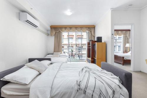 a bedroom with a large bed with white sheets at A Cozy & Spacious Apt for 6 Next to Darling Harbour in Sydney