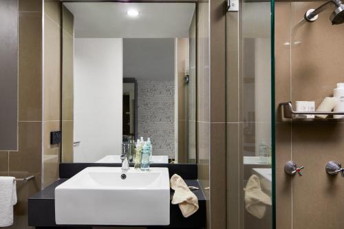 a bathroom with a white sink and a mirror at Punthill Spring Hill in Brisbane