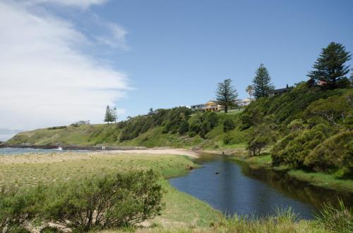 a body of water next to a sandy beach at Kiama Coastal Escape in Kiama