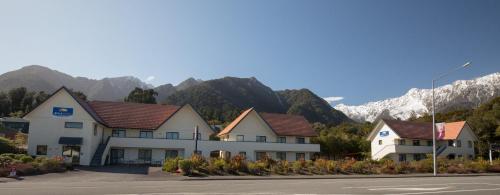 a row of houses in front of a mountain at Bella Vista Motel Fox Glacier in Fox Glacier