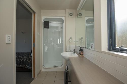 a bathroom with a sink and a shower at Bella Vista Motel Fox Glacier in Fox Glacier