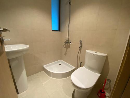 a bathroom with a toilet and a sink with a blue light at The White villa in Fujairah