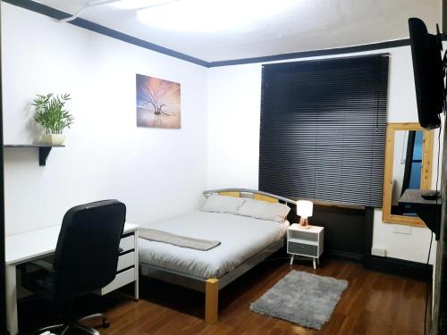 a bedroom with a bed and a desk and a chair at Townhouse 105 in Huddersfield