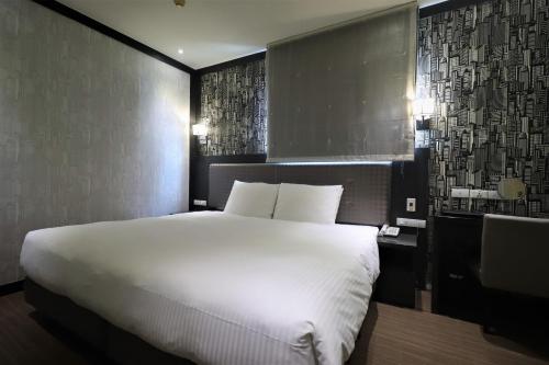 a bedroom with a large white bed in it at J-HOTEL in Kaohsiung