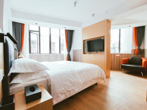 a bedroom with a large bed and a television at Shanghai Fish Inn People Square in Shanghai