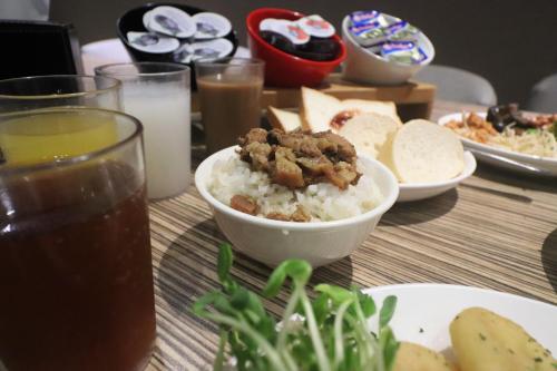 a table topped with a bowl of rice and food at J-HOTEL in Kaohsiung