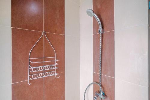 une douche avec pommeau de douche dans une salle de bain dans l'établissement Compact and Simple Studio Apartment at Saladdin Mansion By Travelio, à Parungmalela