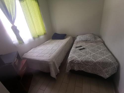 a small bedroom with two beds and a window at Departamento 3 dormitorios sector sur piso bajo in Antofagasta