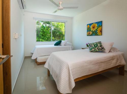 two beds in a room with a window at Magico Apartamento Frente al Mar 3 Habitaciones B21 in Coveñas