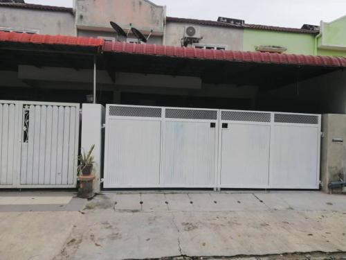 a pair of white gates in front of a building at lost world of tambun muslim guest house in Ipoh