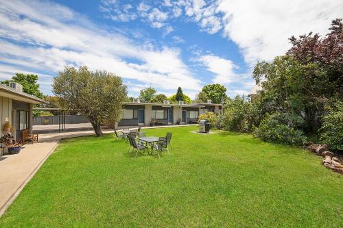 a yard with a table and chairs on the grass at Hamilton Lakeside Motel in Hamilton