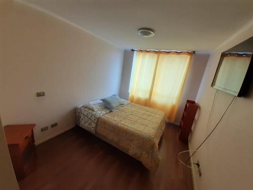 アントファガスタにあるDepartamento Central Familiarのベッドと窓のある小さな寝室