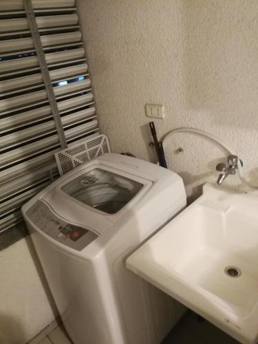 a bathroom with a toilet and a sink at Departamento Central Familiar in Antofagasta