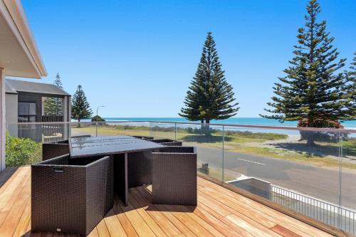 a balcony with a table and a view of the ocean at Ohope Beachside Retreat - Ohope Holiday Home in Ohope Beach