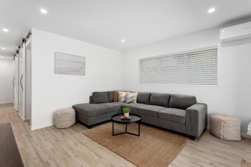 a living room with a couch and a table at Ohope Beachside Retreat - Ohope Holiday Home in Ohope Beach