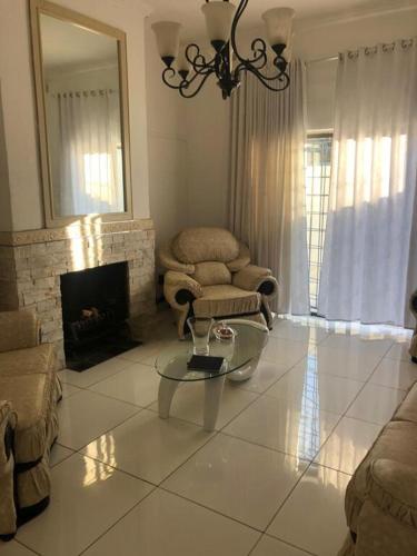 a living room with a fireplace and a glass table at Casa 57 in Pietermaritzburg