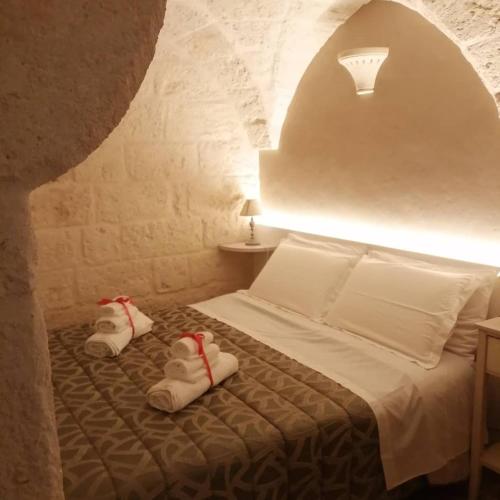 a bedroom with a bed with slippers on it at Al Caveau - Holiday House in Fasano