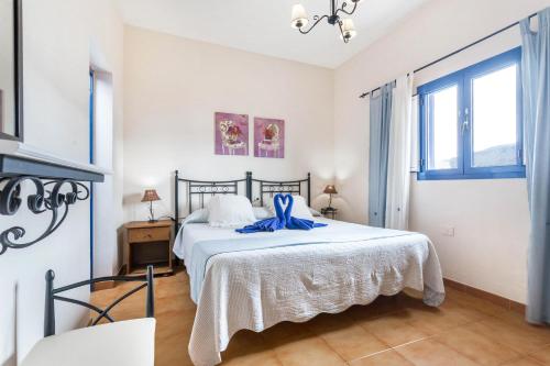 una camera da letto con un letto con un nastro blu sopra di El Sombrerito 6 a Caleta de Sebo