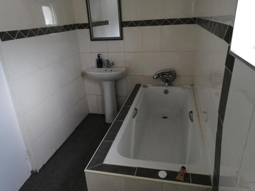 a bathroom with a bath tub and a sink at Casa 57 in Pietermaritzburg