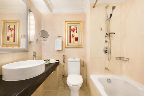a bathroom with a sink and a toilet and a tub at Ramada Plaza by Wyndham Karachi Airport Hotel in Karachi