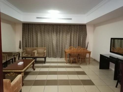 a living room with a table and chairs at Al Massa Hotel Apartments 1 in Al Ain