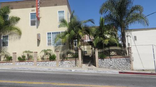 un edificio con una valla y palmeras delante en Trylon Hotel - Hollywood, en Los Ángeles