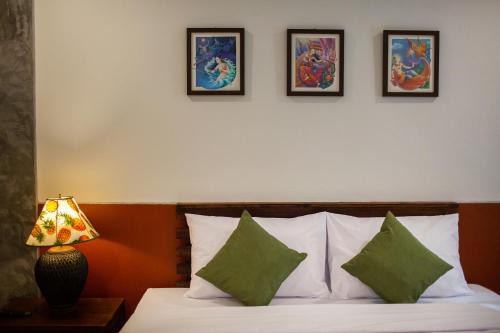 a bedroom with a bed with four pictures on the wall at Phangnga Keeree Resort & Gallery in Phang-nga