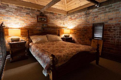 a bedroom with a large bed in a brick wall at Grampians Historic Tobacco Kiln in Moutajup