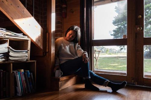 a woman sitting on a window sill in a room at Grampians Historic Tobacco Kiln in Moutajup