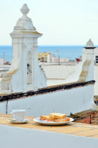 a plate of bread and a cup of coffee on a table at Hostal Campito in Conil de la Frontera