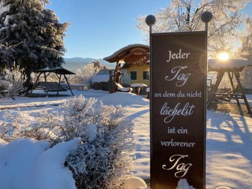 a sign in the snow in front of a house at Hotel Gasthof zur Linde in Mariahof