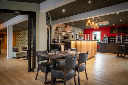 uma sala de jantar com mesa e cadeiras em Zenith Hotel Caen em Caen