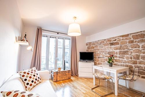 a living room with a stone wall at Weinhotel Ayler Kupp in Ayl