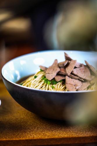 a bowl of noodles with meat on top of it at Crowne Plaza Zhenjiang by IHG in Zhenjiang