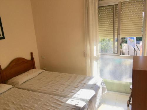 Schlafzimmer mit einem Bett und einem Fenster mit Jalousien in der Unterkunft SUN and BEACH LOVERS 12019 in La Pineda