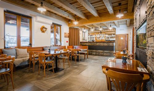 a restaurant with wooden tables and chairs and a bar at Rodinný penzion Sobáčov in Sobačov
