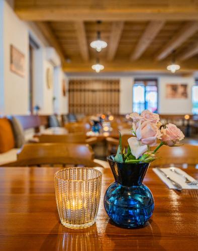 a blue vase with flowers on a wooden table at Rodinný penzion Sobáčov in Sobačov