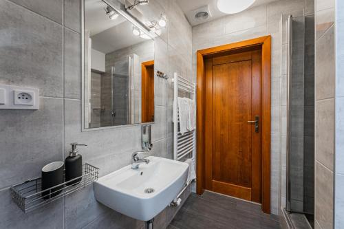 a bathroom with a sink and a wooden door at Rodinný penzion Sobáčov in Sobačov