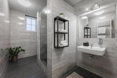 a white bathroom with a sink and a shower at Rodinný penzion Sobáčov in Sobačov