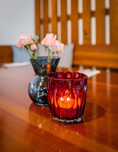a candle and a vase with flowers on a table at Rodinný penzion Sobáčov in Sobačov