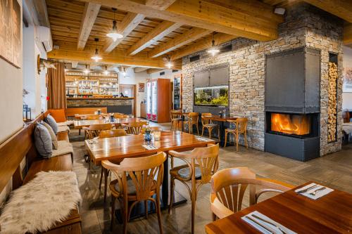a restaurant with wooden tables and a fireplace at Rodinný penzion Sobáčov in Sobačov