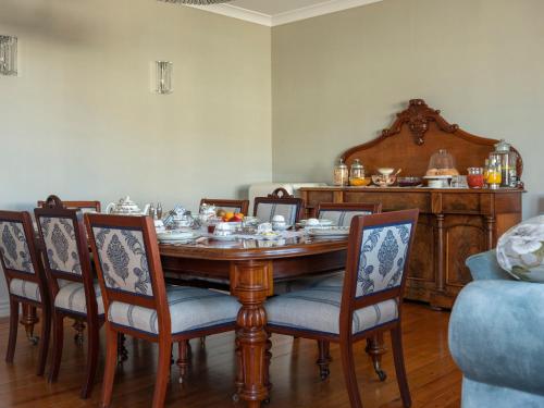 a dining room with a wooden table and chairs at 415 Marine Parade in Napier