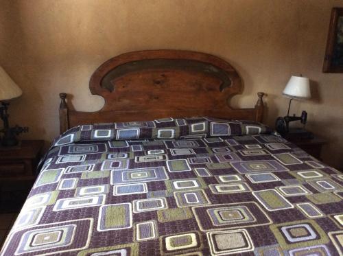 a bed with a wooden head board in a bedroom at Hosteria Covadonga in Perote