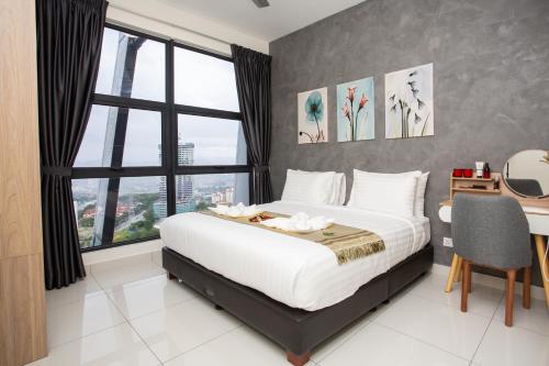 a bedroom with a bed and a desk and windows at ARTE MONT KIARA BY PSM Luxury Suites in Kuala Lumpur