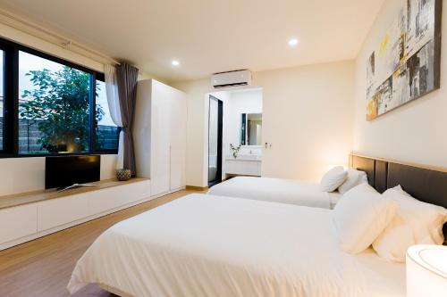 2 Betten in einem Schlafzimmer mit Fenster in der Unterkunft COASTAR SAKI HO TRAM in Xuyên Mộc